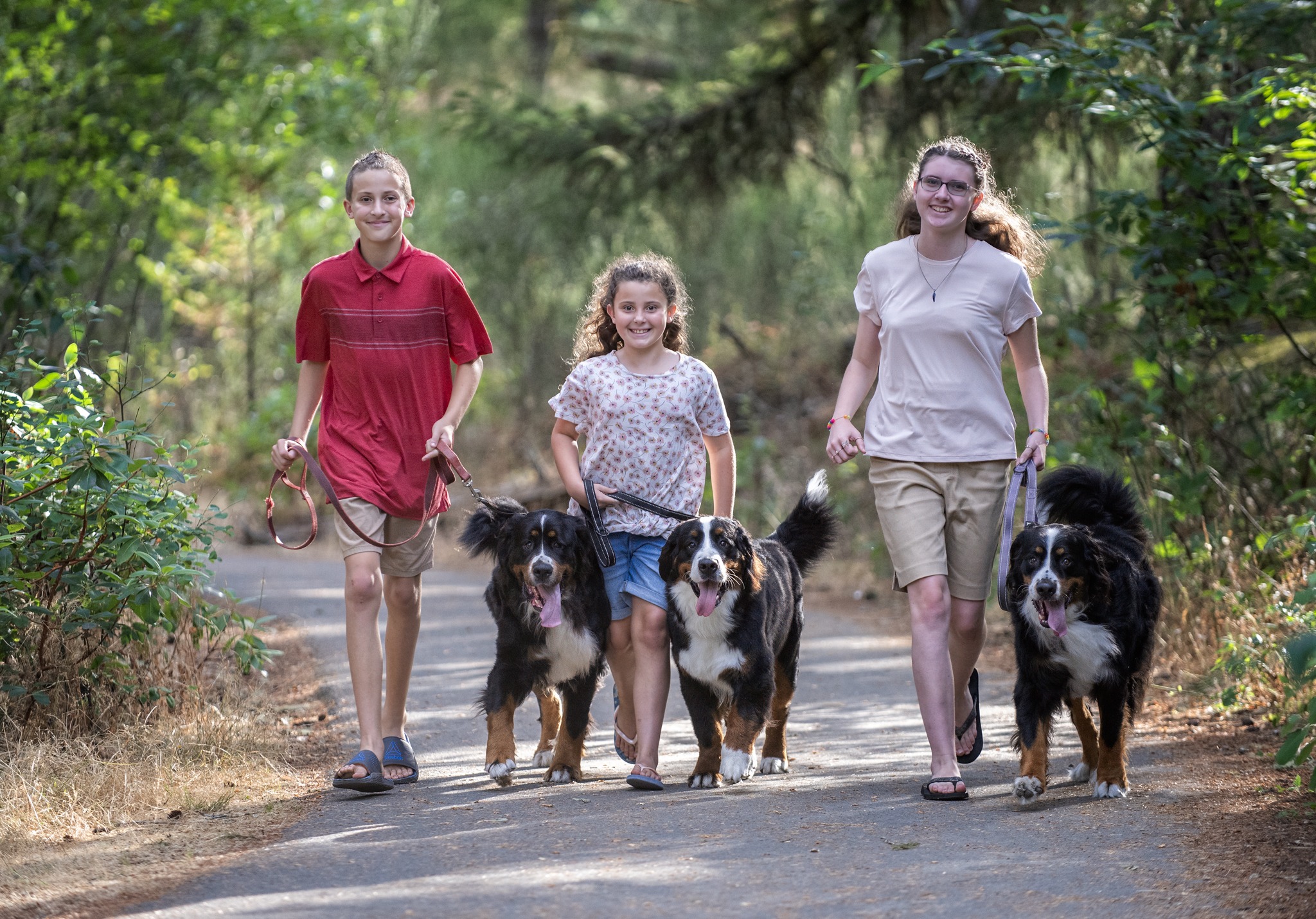 Three Children running down a path with their dogs!